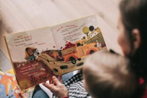 Picture of a woman reading to a baby and a picture of the children's book in her hands.