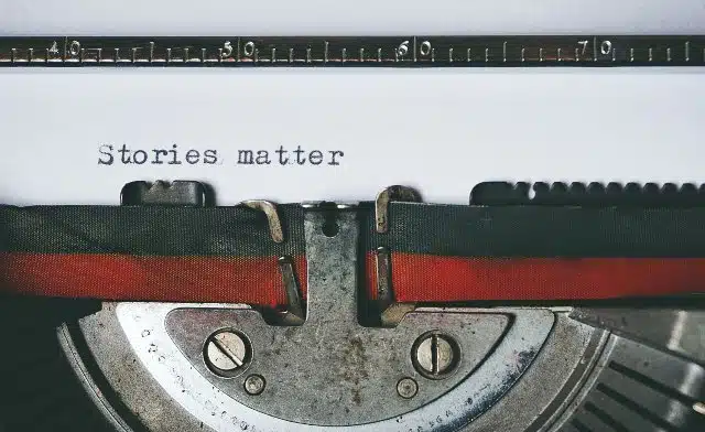 Picture of a typewriter with the typed text "Stories matter."